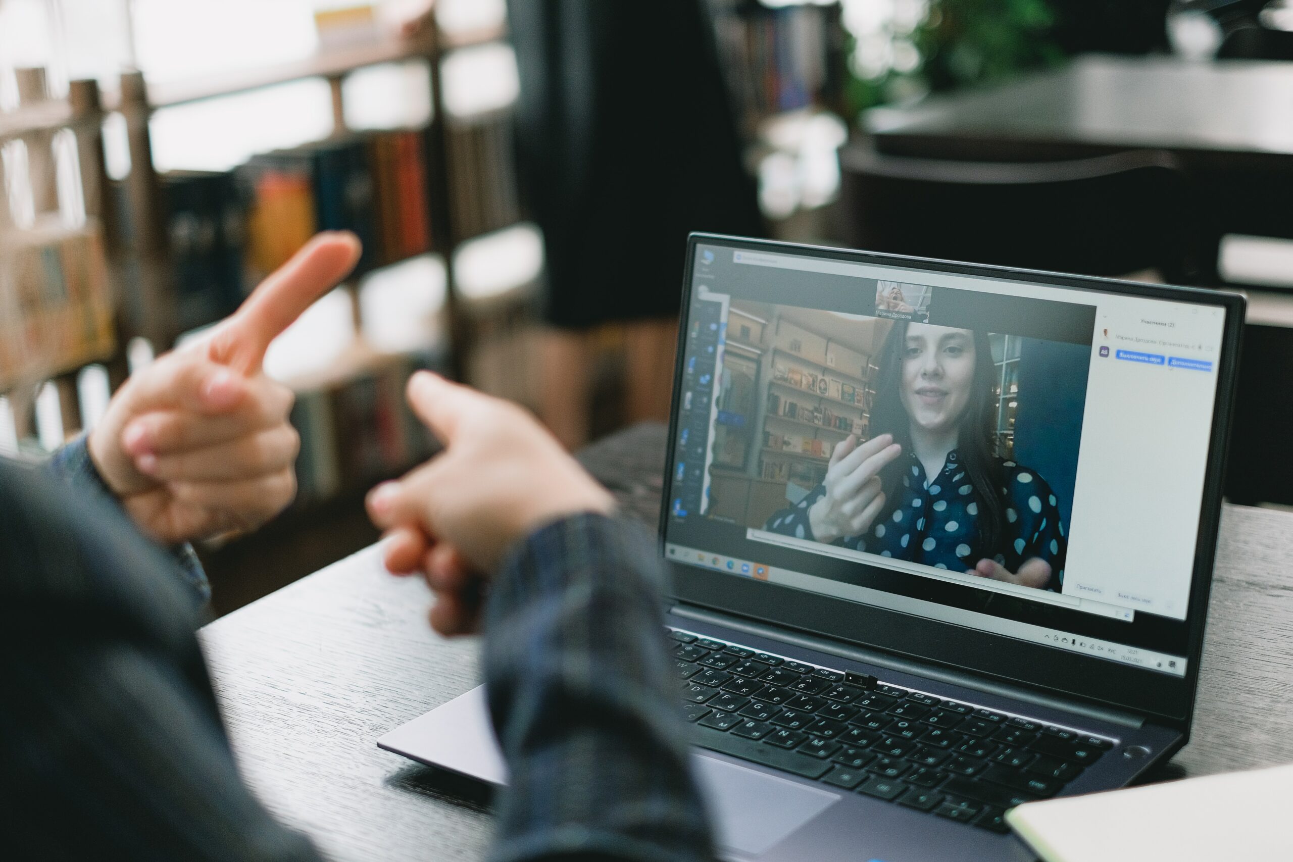 deux personnes communiquent par webcam par le langage des signes pour un service relation client COMEARTH
